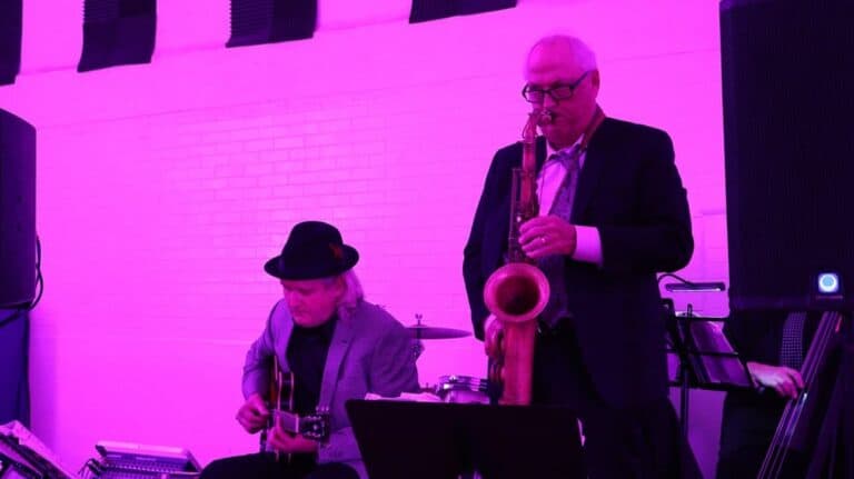 Elegant jazz band performing live entertainment at Velvet Edge Entertainment events with soulful music and vibrant purple lighting.